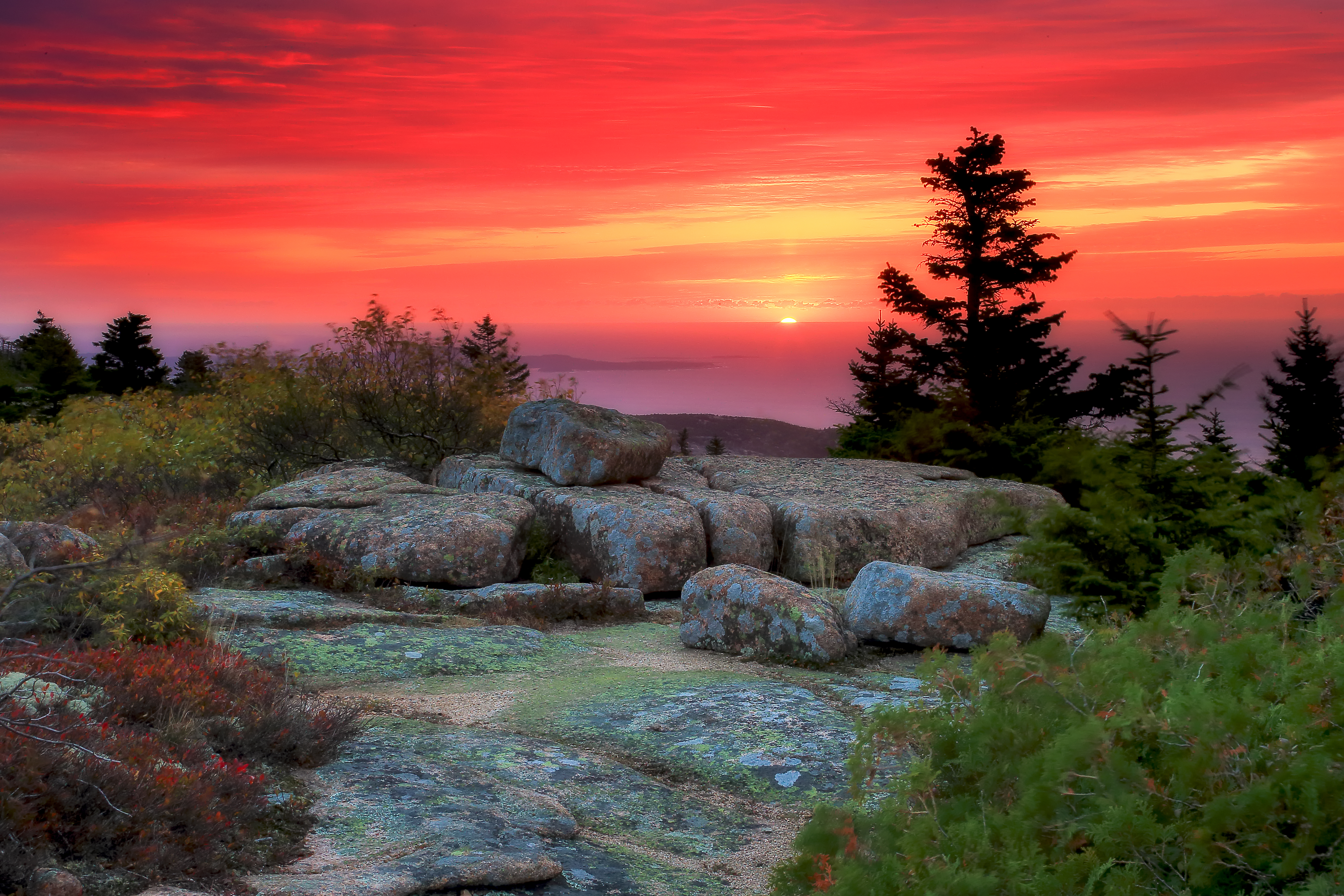 Sunrise over Cadillac Mountain with granite foreground and Atlantic Ocean horizon revealing Acadia’s coastal geology