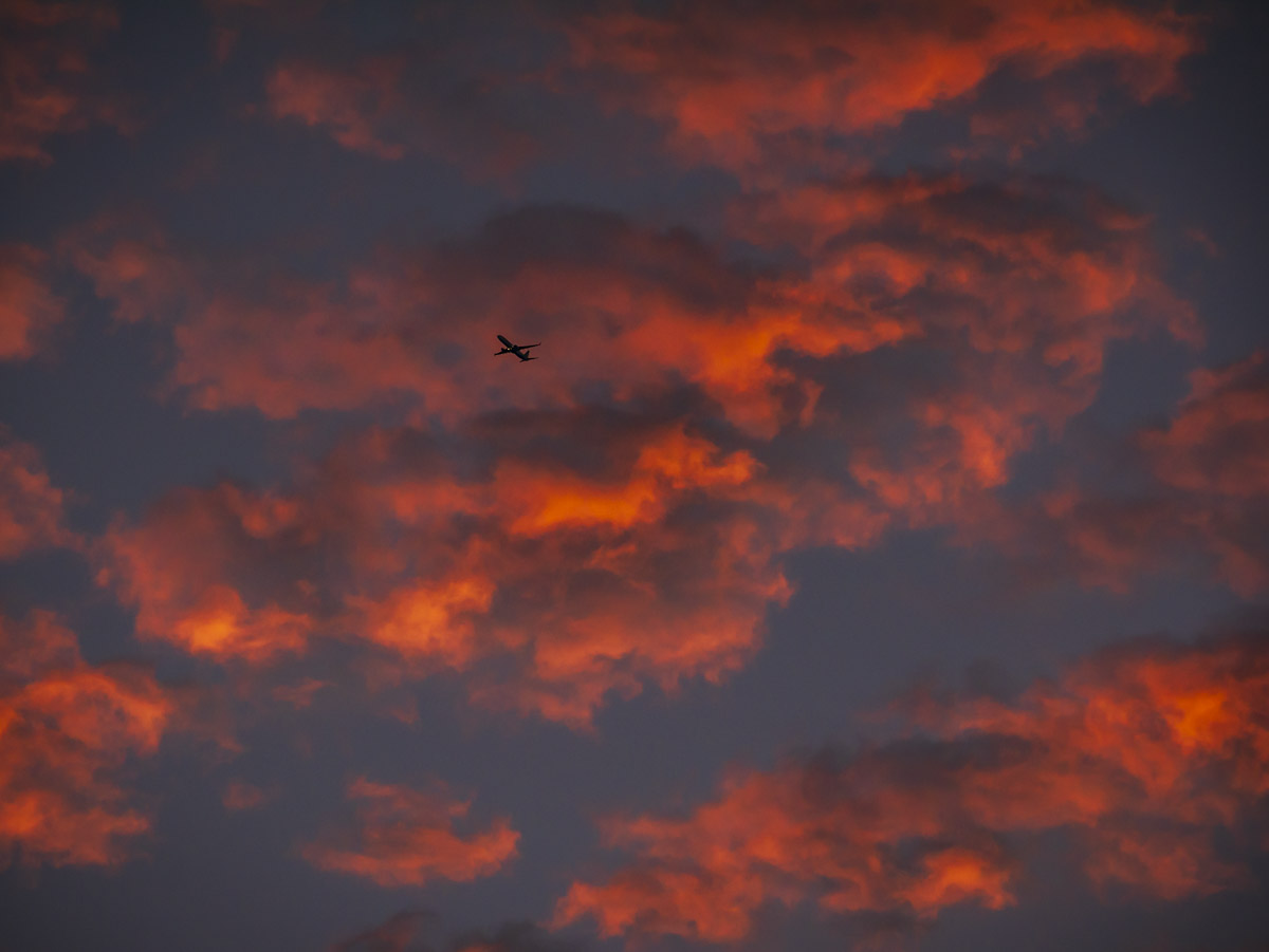 An Atlanta photographer capturing beautiful pink and orange clouds and an airplane