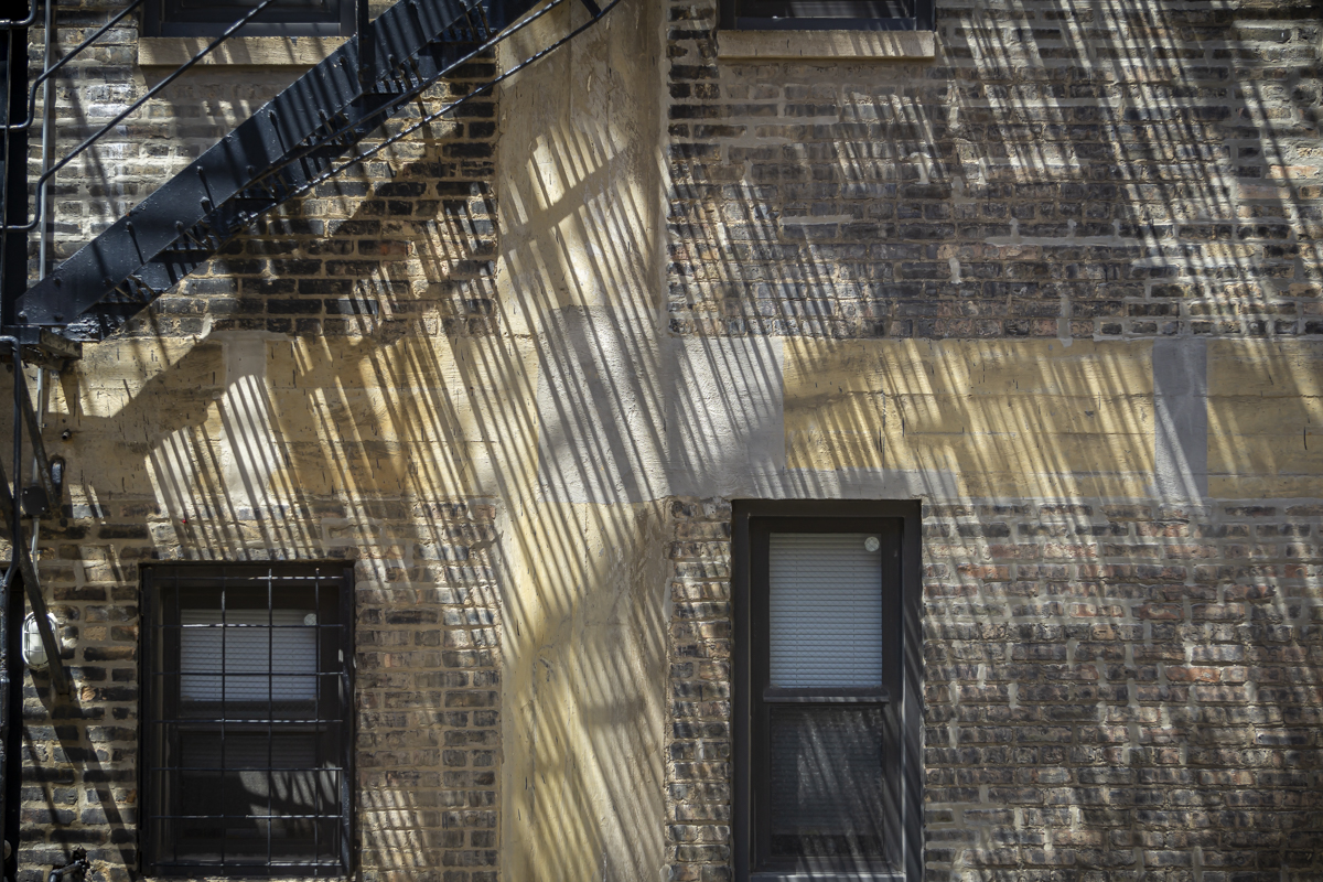 Shadows and light thrown on the wall from the fire escape