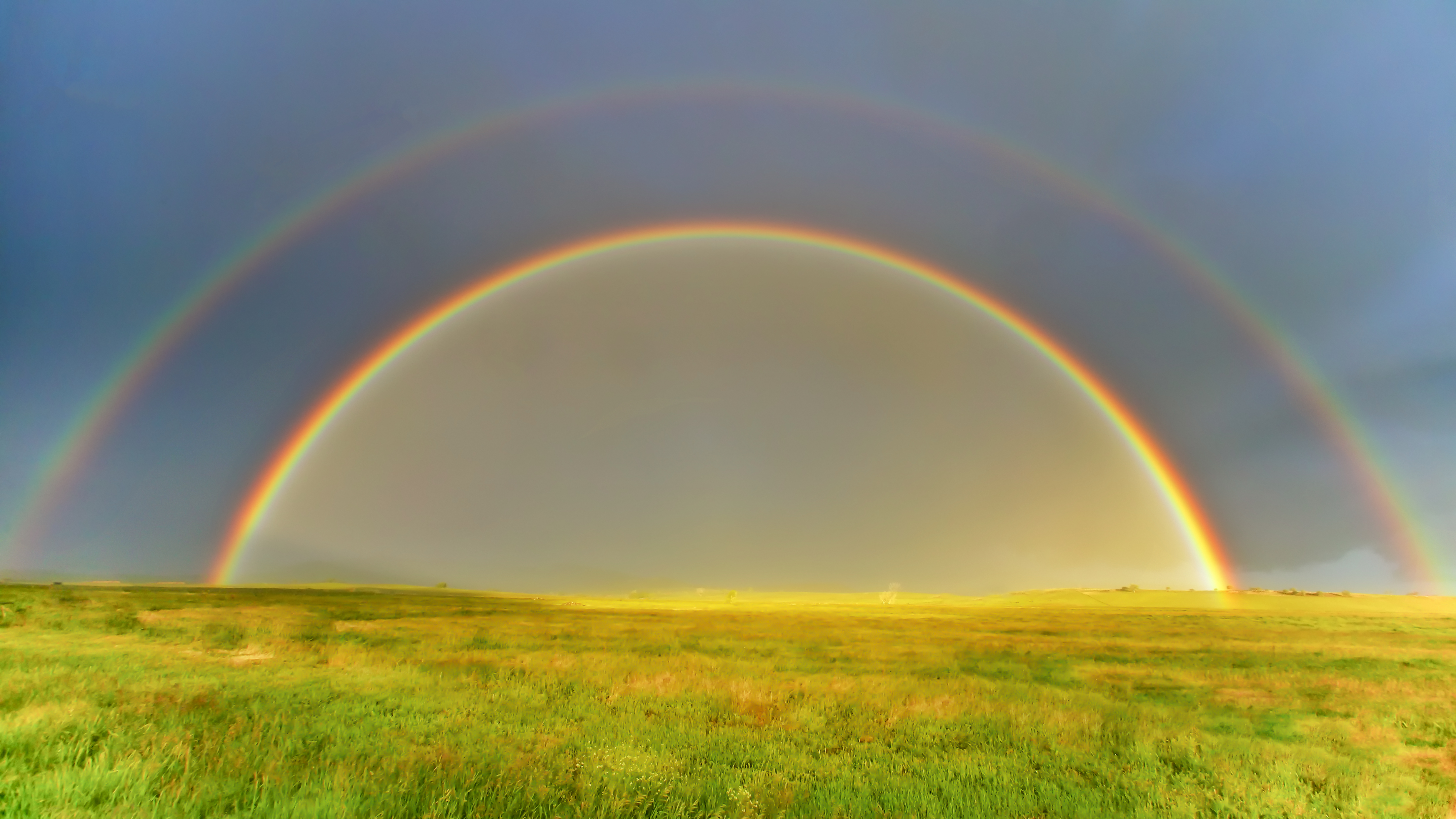 Double rainbow across a prairie — symbol of unified light, breath, memory, and spiral consciousness