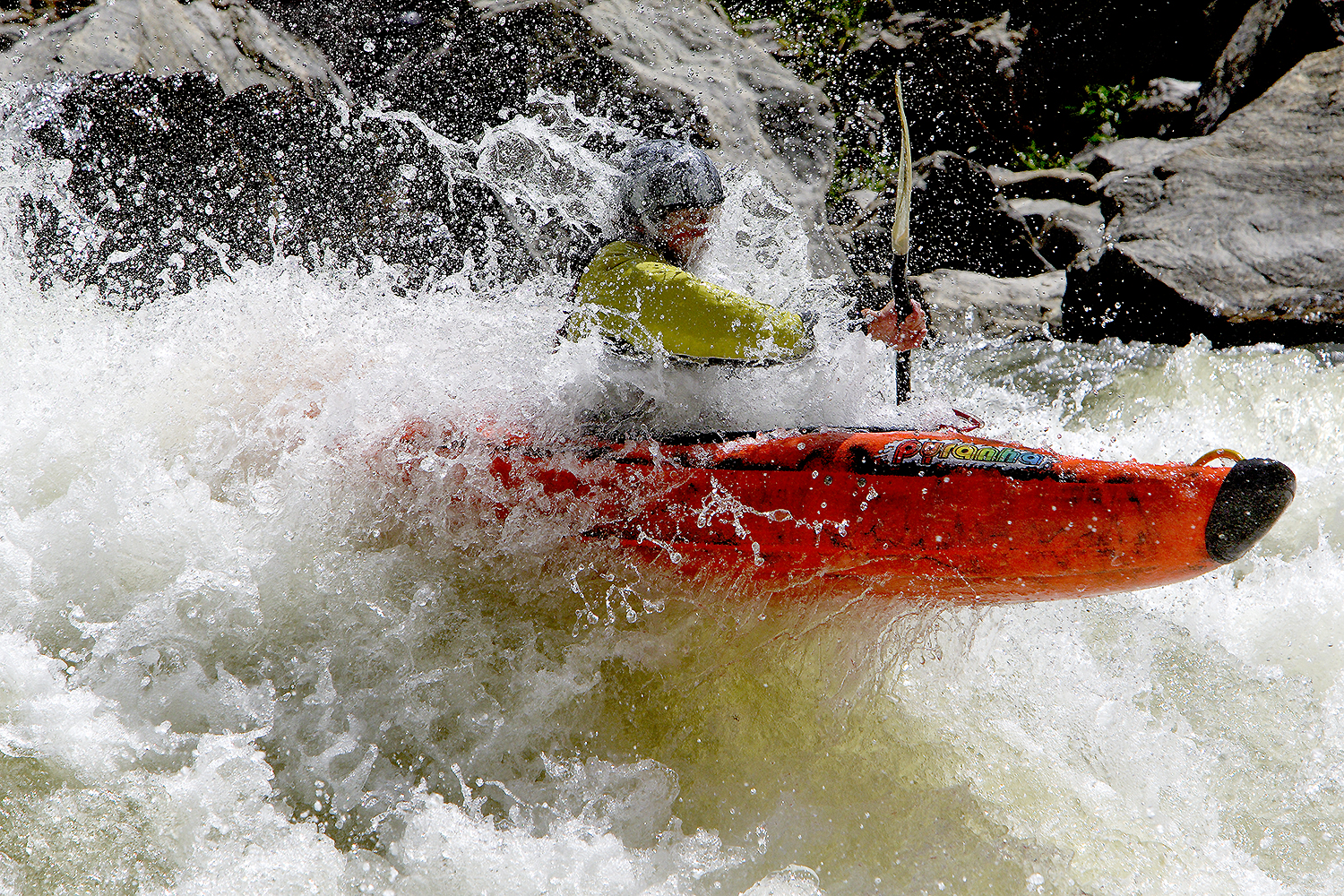 Kayak gliding through a moving river, current bending around rocks and light